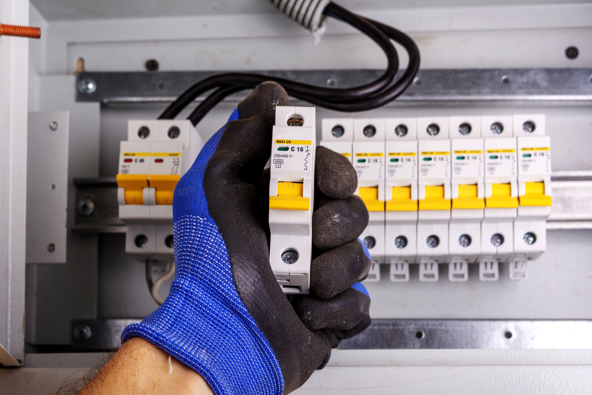 Electrician inspecting a tripped breaker