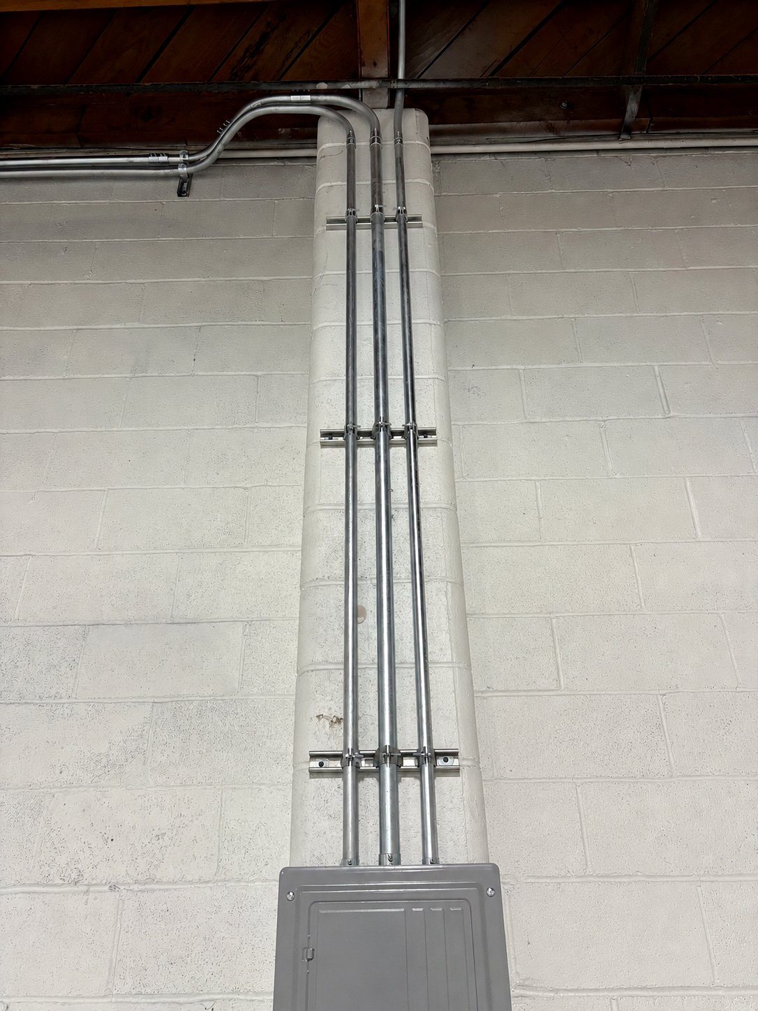 Three-phase conduit risers on a commercial wall